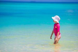 menina adorável na praia durante as férias de verão foto