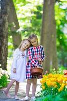 meninas adoráveis andando no exuberante jardim de tulipas foto