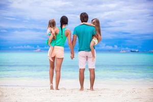 vista traseira da jovem família olhando para o mar nas filipinas foto