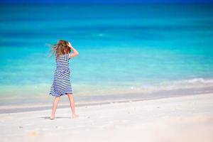 menina adorável na praia durante as férias de verão foto