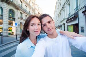 casal jovem feliz tomando selfie em paris ao ar livre foto