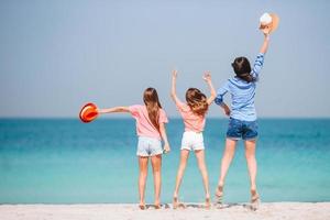 adoráveis meninas e jovem mãe na praia tropical branca foto