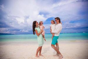 jovem linda família com dois filhos se olhando em férias tropicais foto