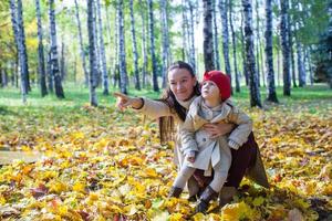 moda jovem mãe e sua adorável filha desfrutando de um dia ensolarado no parque outono
