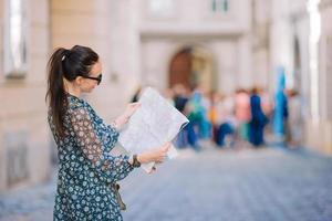 jovem mulher com um mapa da cidade na cidade. menina turista de viagens com mapa em viena ao ar livre durante as férias na europa. foto