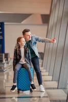 família feliz com bagagem e cartão de embarque no aeroporto à espera de embarque foto