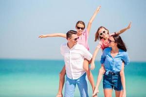 jovem família de quatro de férias de praia foto