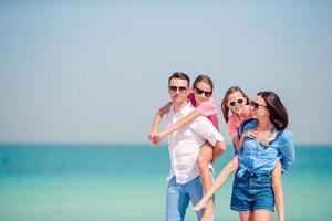 família feliz com crianças na praia juntos foto