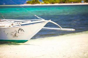 pequeno barco na praia tropical de areia branca foto