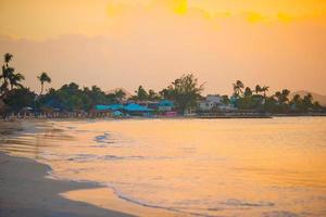 incrível belo pôr do sol em uma praia exótica do Caribe foto