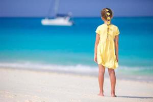 adorável menina na praia com flores no cabelo na praia foto