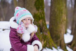 adorável menina feliz divirta-se no dia de neve de inverno foto