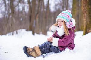 adorável menina feliz divirta-se no dia de neve de inverno ao ar livre foto