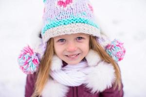 adorável menina feliz divirta-se no dia de neve de inverno ao ar livre foto