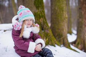 adorável menina feliz divirta-se no dia de neve de inverno ao ar livre foto