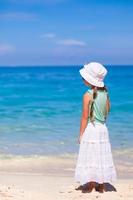 vista traseira da adorável menina na praia tropical foto