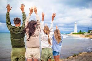 família de quatro pessoas caminha até o farol foto