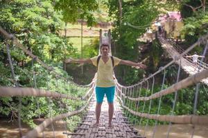 jovem na ponte pênsil sobre o rio loboc, filipinas foto