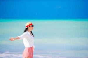 jovem mulher curtindo o banho de sol no oceano azul-turquesa perfeito. foto