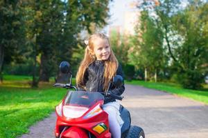 retrato de menina adorável rock na jaqueta de couro, sentado em sua bicicleta foto