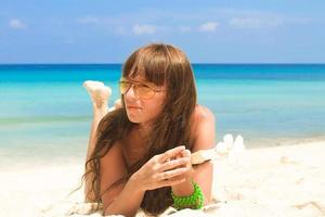 jovem mulher lendo o livro na praia branca tropical foto