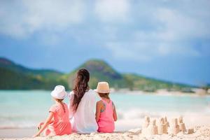 linda mãe e suas adoráveis filhas na praia foto