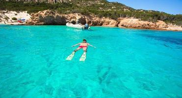 jovem mergulhando em águas cristalinas tropicais azul-turquesa foto