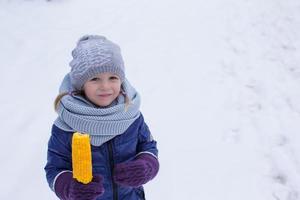 menina comendo milho ao ar livre num dia de inverno foto