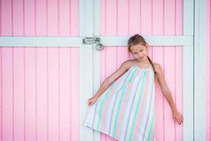 adorável menina ao ar livre perto da tradicional casa rosa colorida do Caribe foto