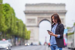 linda mulher segurando um telefone na champs elysees em paris foto