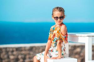 hora do almoço. menina tomando café da manhã no café ao ar livre com vista para o mar foto