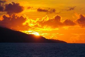 incrível pôr do sol colorido em uma praia exótica em seychelles foto