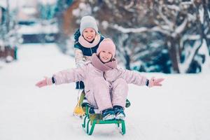 adoráveis meninas felizes trenó em dia de inverno nevado. foto
