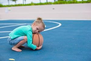 menina com basquete na quadra no resort tropical foto