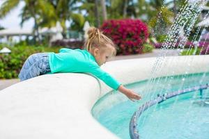 menina adorável em um belo hotel exótico perto da fonte foto