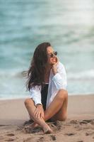 jovem mulher bonita relaxar na praia foto