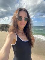 jovem mulher bonita tomando selfie na praia foto