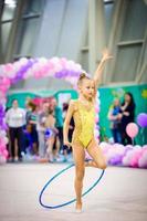 pequena linda ginasta no tapete. adorável ginasta participa de competições de ginástica rítmica foto