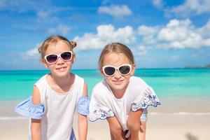 retrato de duas lindas crianças olhando para o fundo da câmera da bela natureza do céu azul e mar turquesa foto