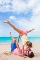 família de pai e menina esportiva se divertindo na praia foto