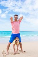 família de pai e menina esportiva se divertindo na praia foto