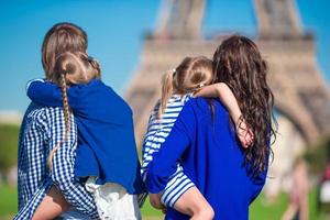 família feliz com dois filhos em paris perto da torre eiffel foto