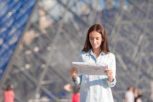 jovem mulher com mapa na cidade europeia ao ar livre foto