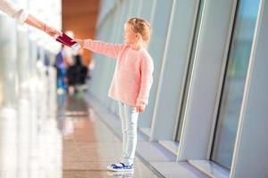 menina com cartão de embarque no aeroporto à espera de voo foto
