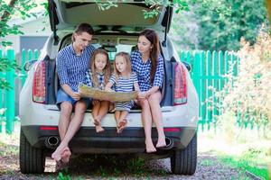 família com dois filhos olhando o mapa enquanto viaja de carro foto