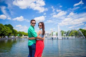 casal jovem turista viajando de férias na europa sorrindo feliz. menina caucasiana e fundo do homem da fonte foto