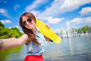 jovem se divertindo com skate no parque. retrato do estilo de vida de uma jovem mulher positiva se divertindo e aproveitando o clima quente. foto