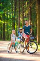 família feliz andando de bicicleta ao ar livre no parque foto