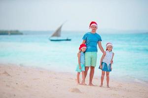 pai com filhos nas férias de natal. natal férias em família na praia foto