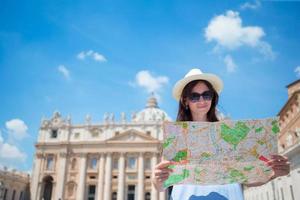 jovem feliz com mapa da cidade na cidade do vaticano e st. Igreja da Basílica de São Pedro, Roma, Itália. mulher de turista de viagens com mapa ao ar livre durante as férias na europa. foto